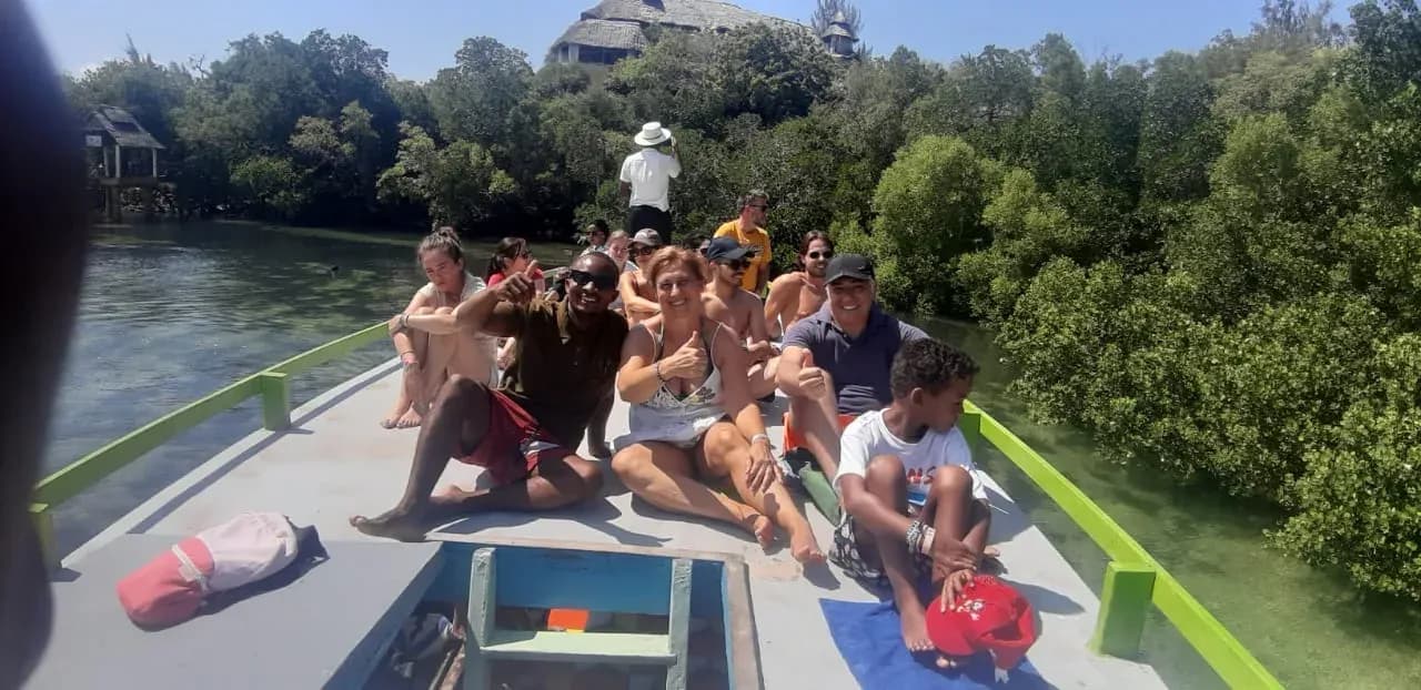 Ospiti seduti a prua mentre la barca passa fra le mangrovie.